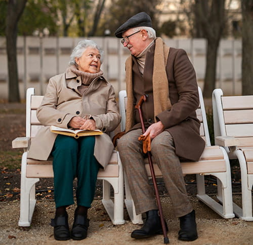 two old people sitting on a bench